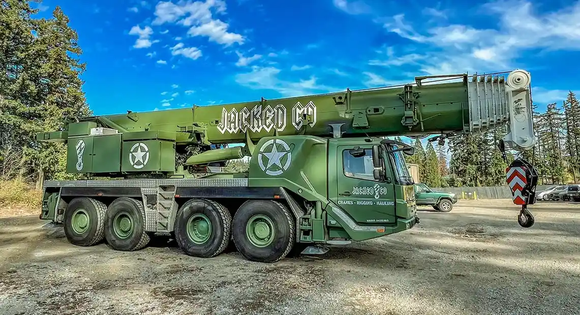 Side profile of the custom "Jacked Co." olive drab mobile crane featuring military-style branding and high-capacity boom.