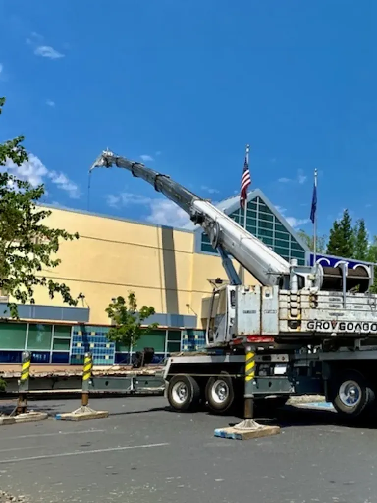 Grove mobile crane by Jacked Co. performing a rooftop mechanical lift for a commercial building project.
