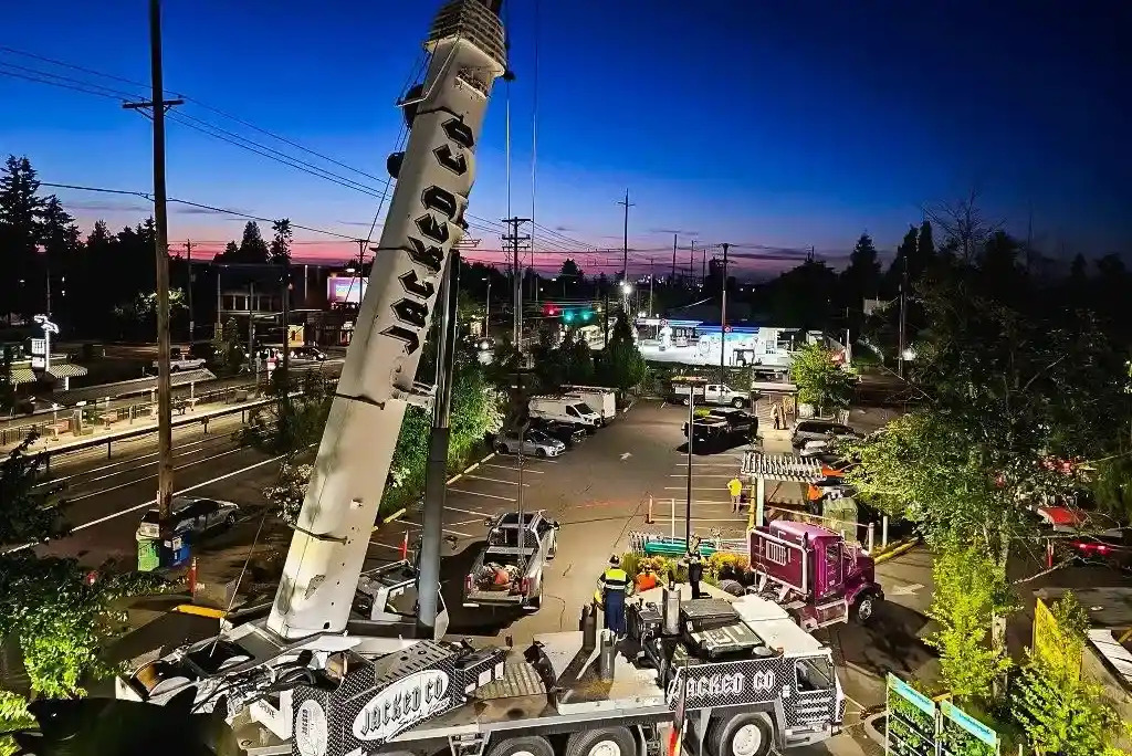 Nighttime rigging operations by Jacked Co. in a well-lit parking area during a commercial equipment swap.