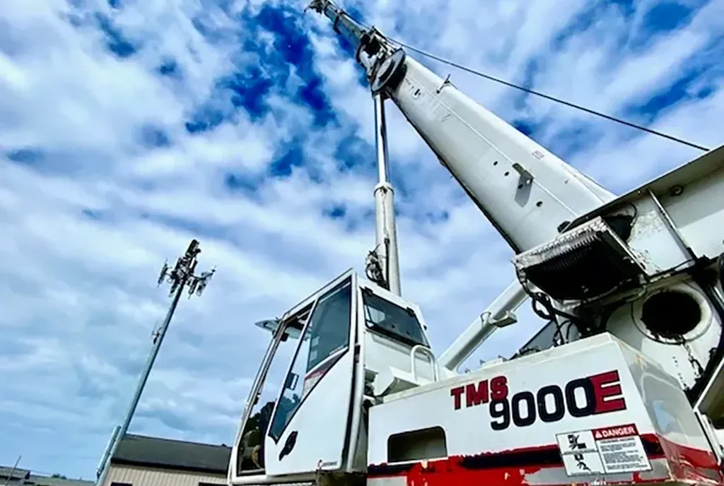 Wide-angle view of a Jacked Co. TMS9000E crane boom extending to service a telecommunications tower.