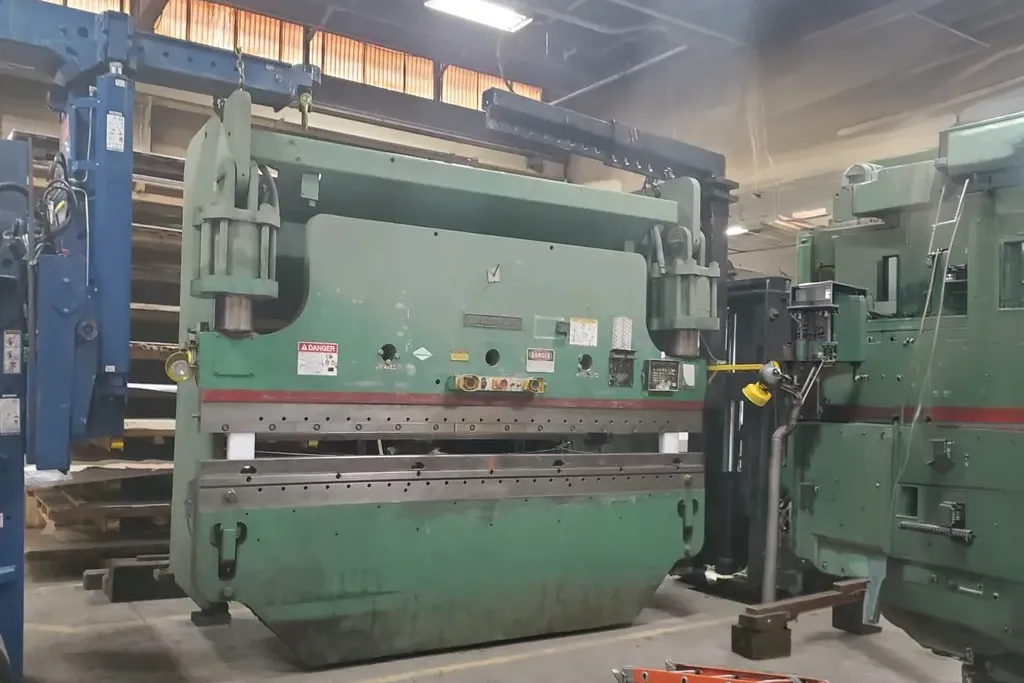 Large green industrial metal press.