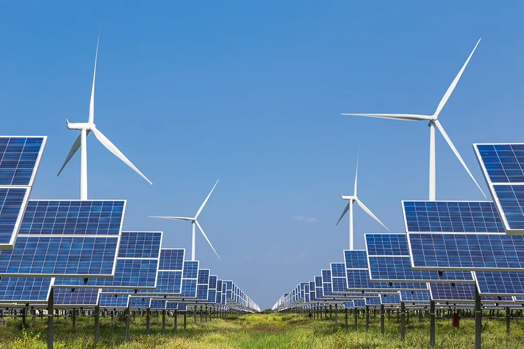 Wide-angle view of a large-scale solar farm integrated with wind turbines for a renewable energy infrastructure project.